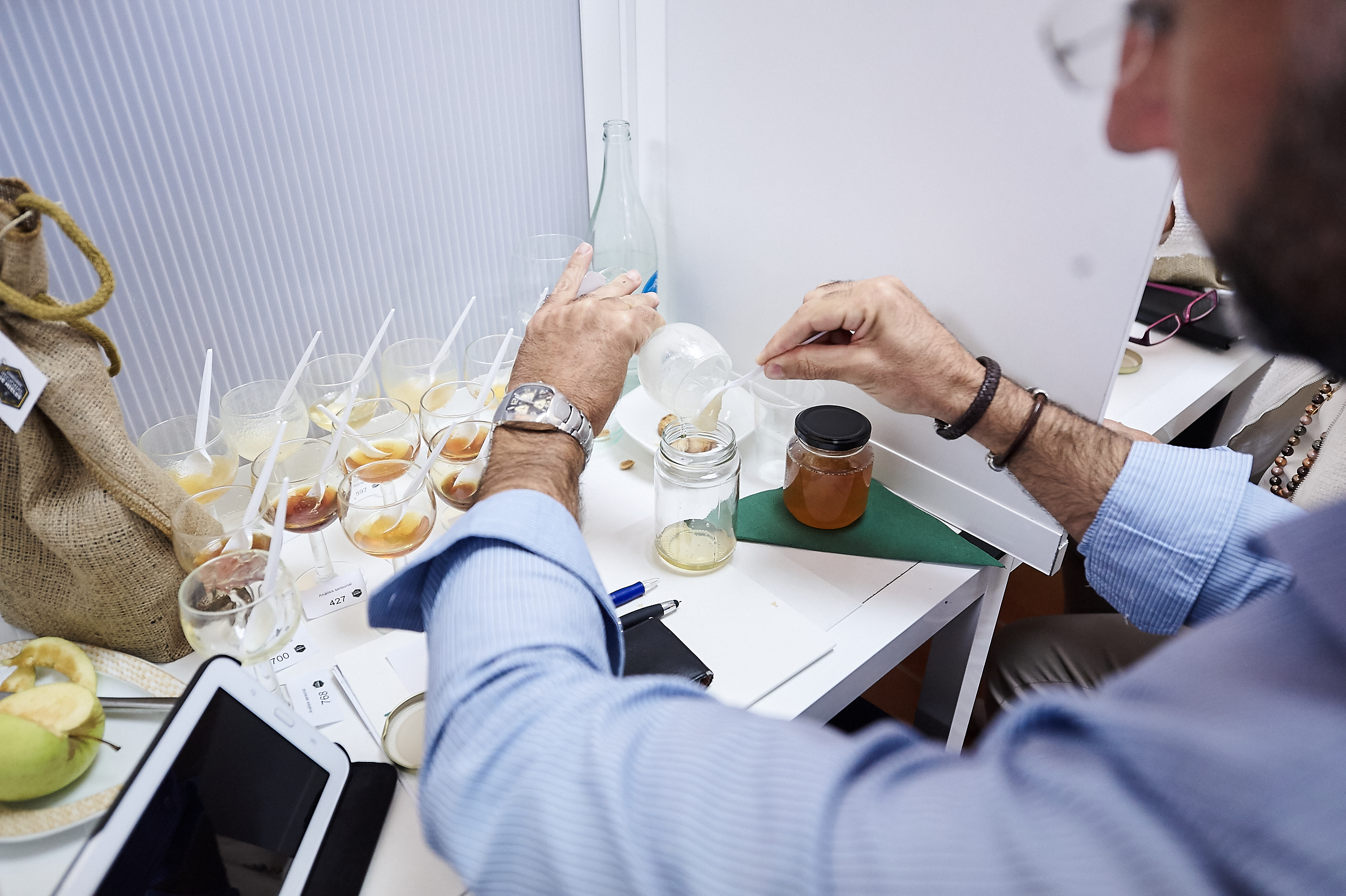 Un miembro del jurado examina una de las muestras de miel