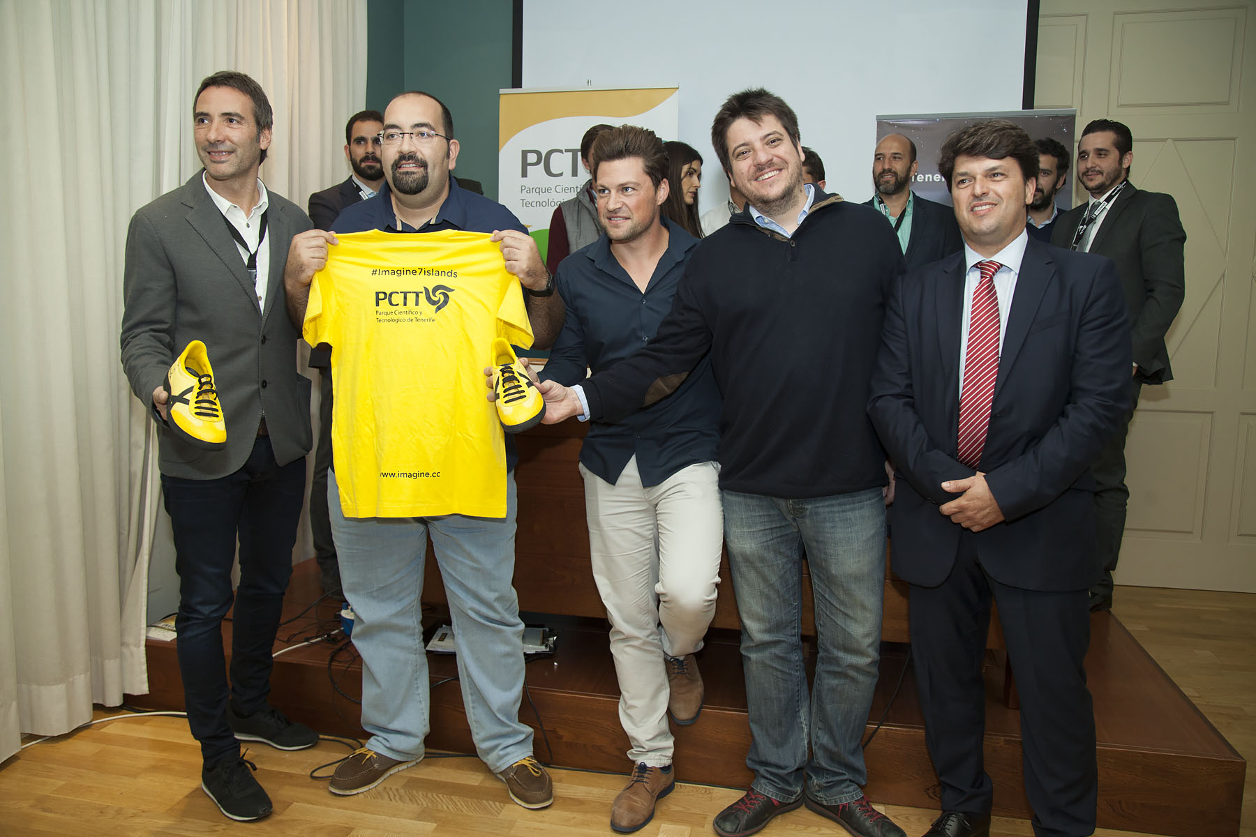 El ganador del TF Invierte, Oliver González, posa con la camiseta amarilla que le acredita como 'dreamer' del proyecto Imagine 7 Islands junto al consejero Antonio García Marichal y otros emprendedores