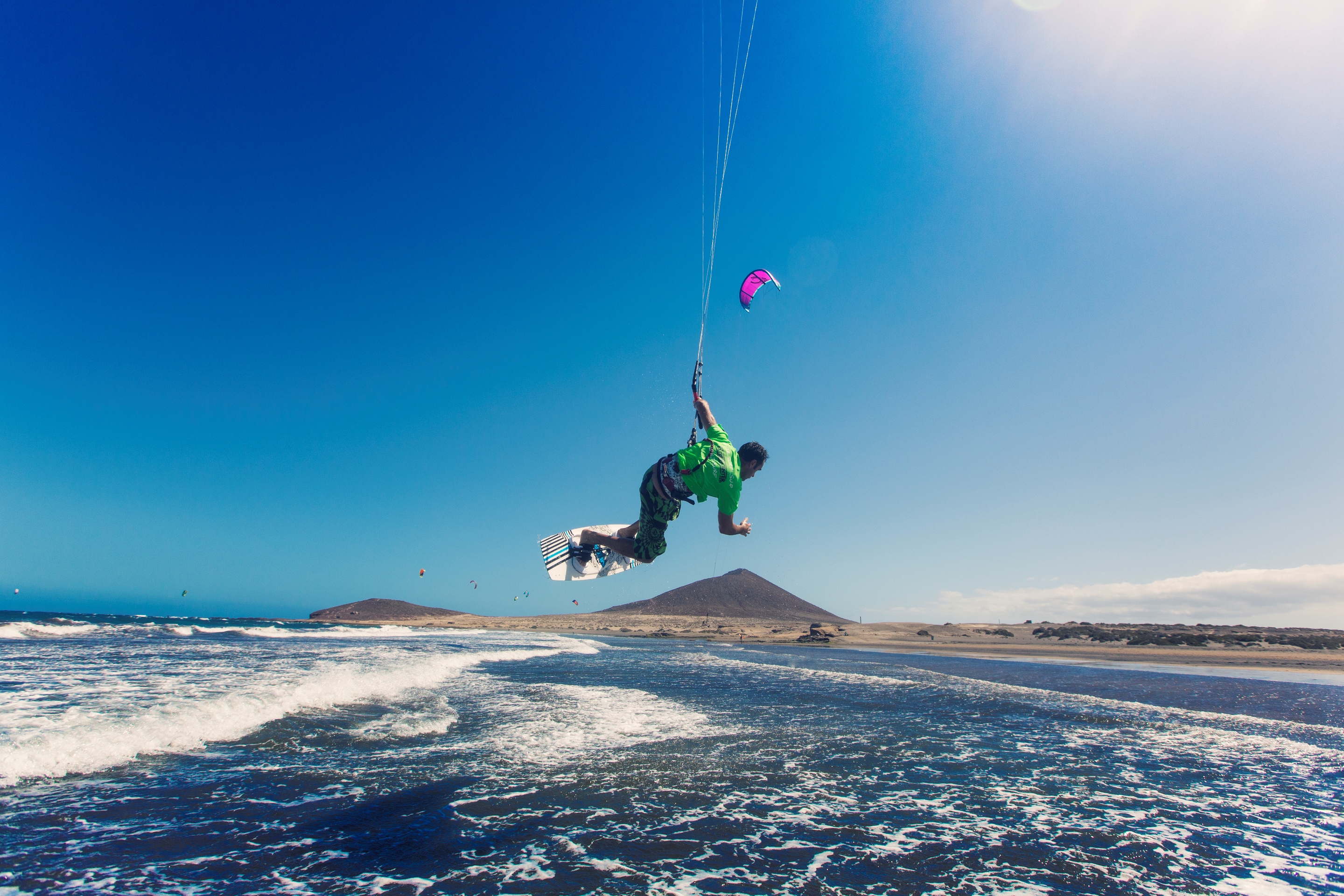 Un deportista realiza una acrobacia de kite surf en la playa de El Médano